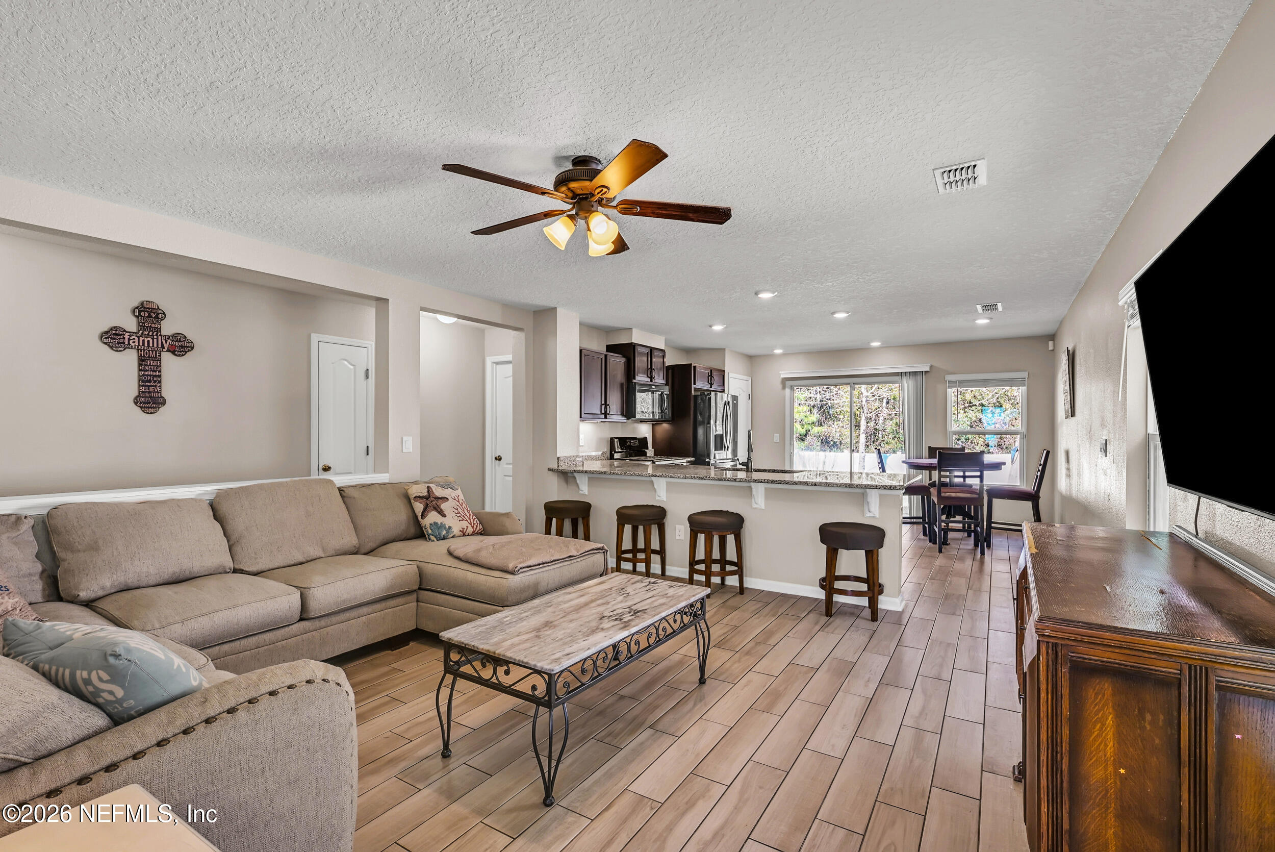 532 Bluejack Lane St. Augustine, FL 32095 - Photo 5 of 55 a living room with furniture a flat screen tv and kitchen view