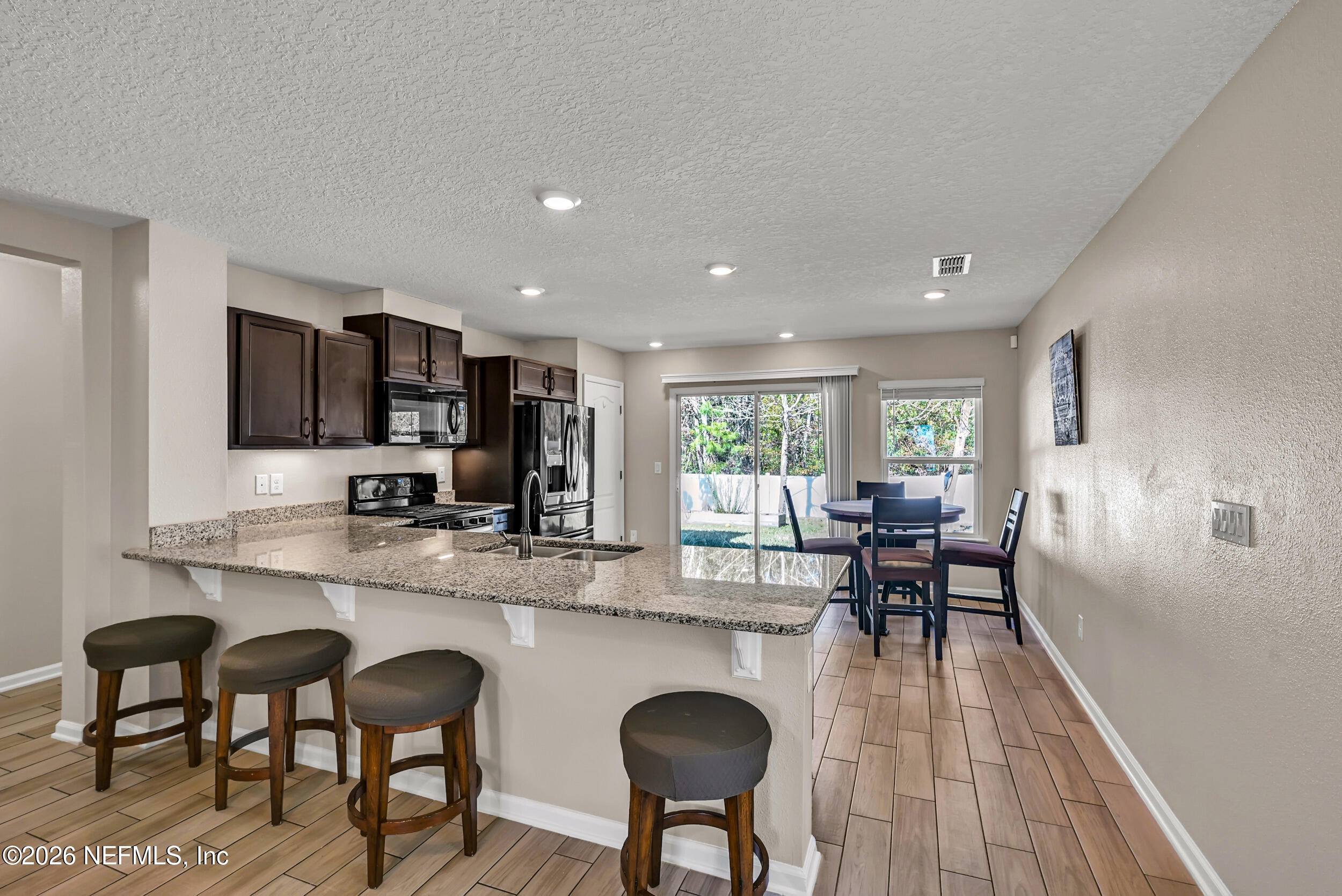 532 Bluejack Lane St. Augustine, FL 32095 - Photo 9 of 55 a kitchen with granite countertop dining table chairs and white appliances