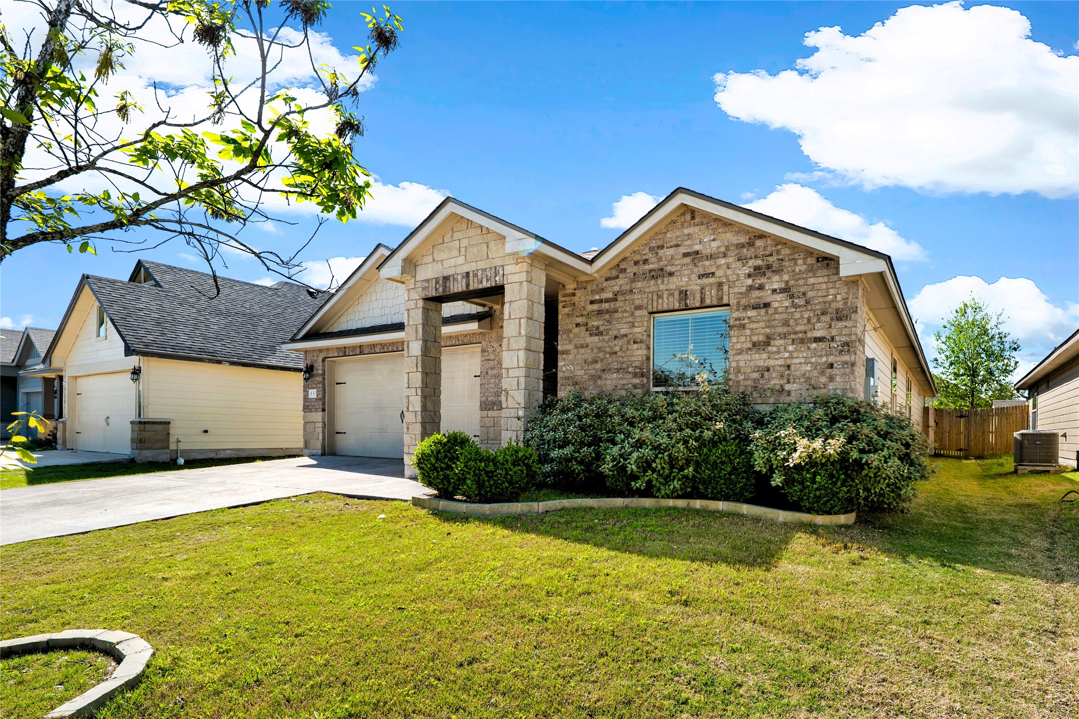 View of front of property featuring concrete driveway, a front yard, a garage, and brick siding