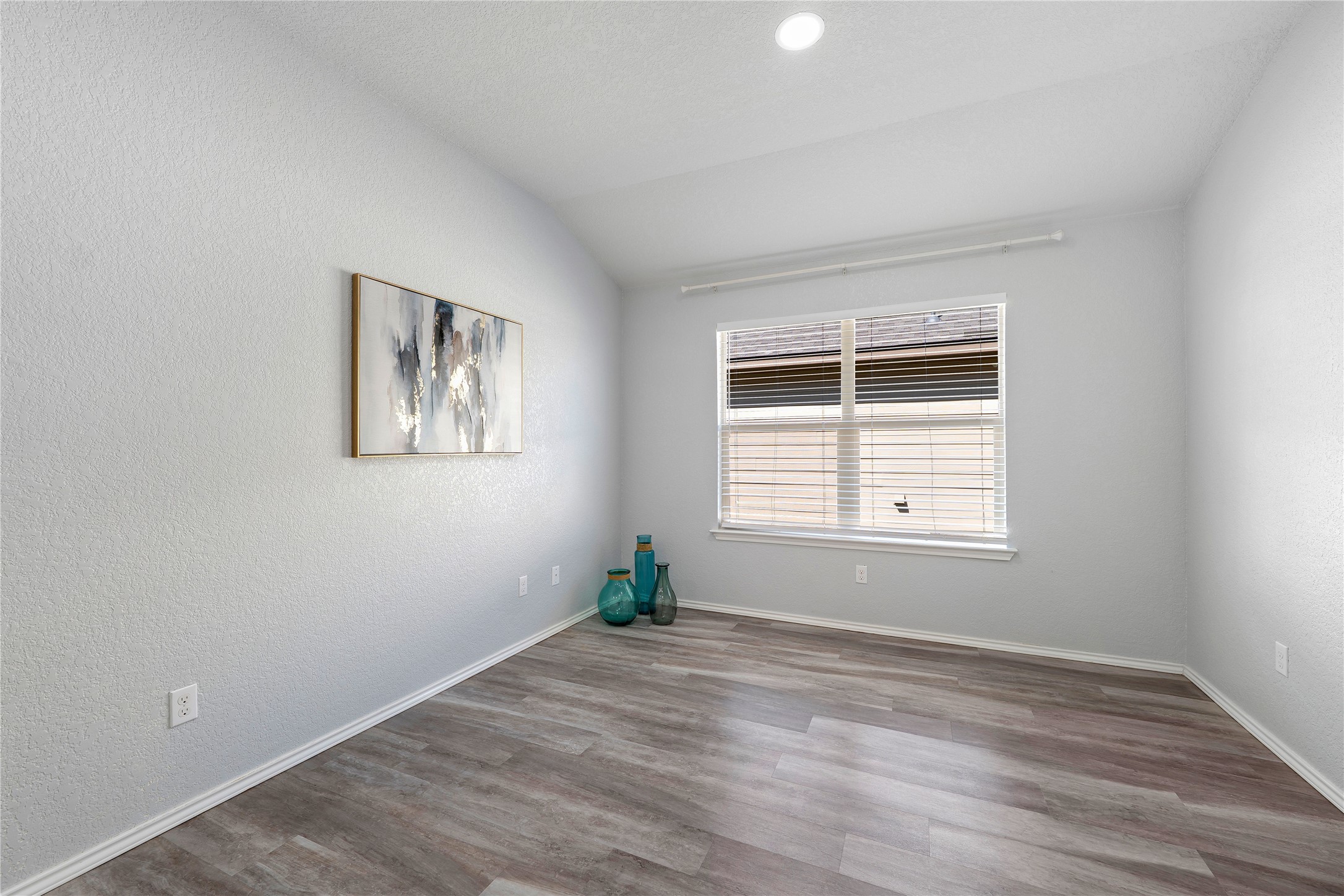 133 Beth Ann Loop Taylor, TX 76574 - Photo 2 of 30 Empty room featuring vaulted ceiling, dark engineering flooring and a textured wall