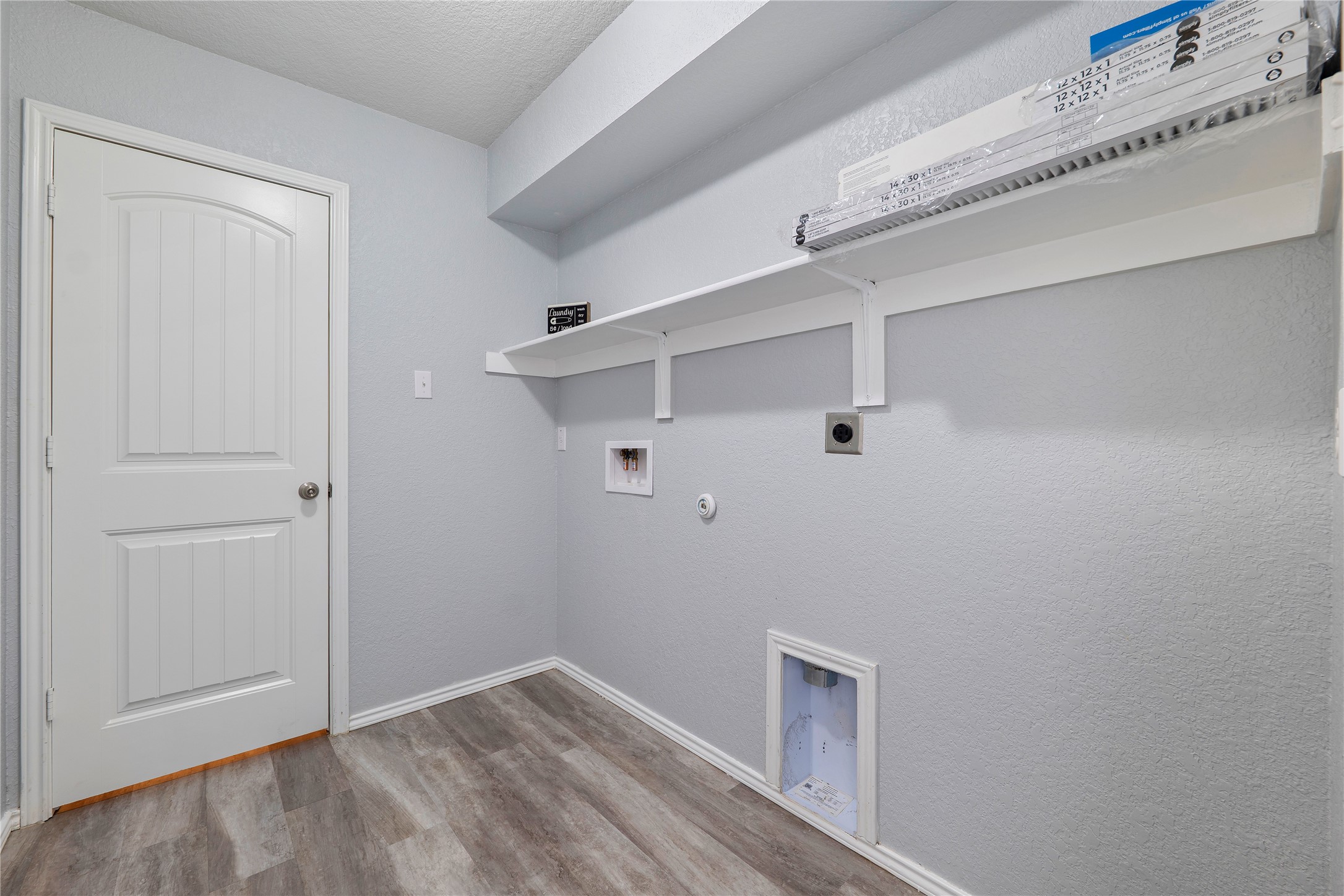 133 Beth Ann Loop Taylor, TX 76574 - Photo 22 of 30 Laundry area with hookup for a gas dryer, wood finished floors, electric dryer hookup, washer hookup, and a textured wall