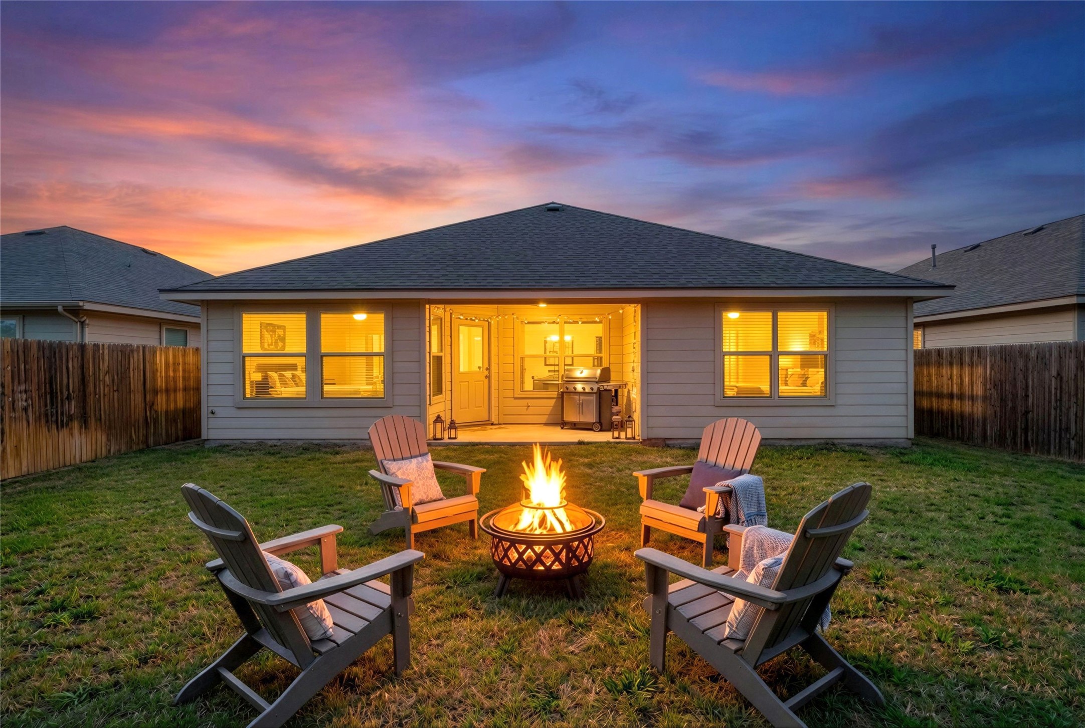 133 Beth Ann Loop Taylor, TX 76574 - Photo 24 of 30 Virtual stage Back of property at dusk with a patio, a fenced backyard, a shingled roof, and a fire pit