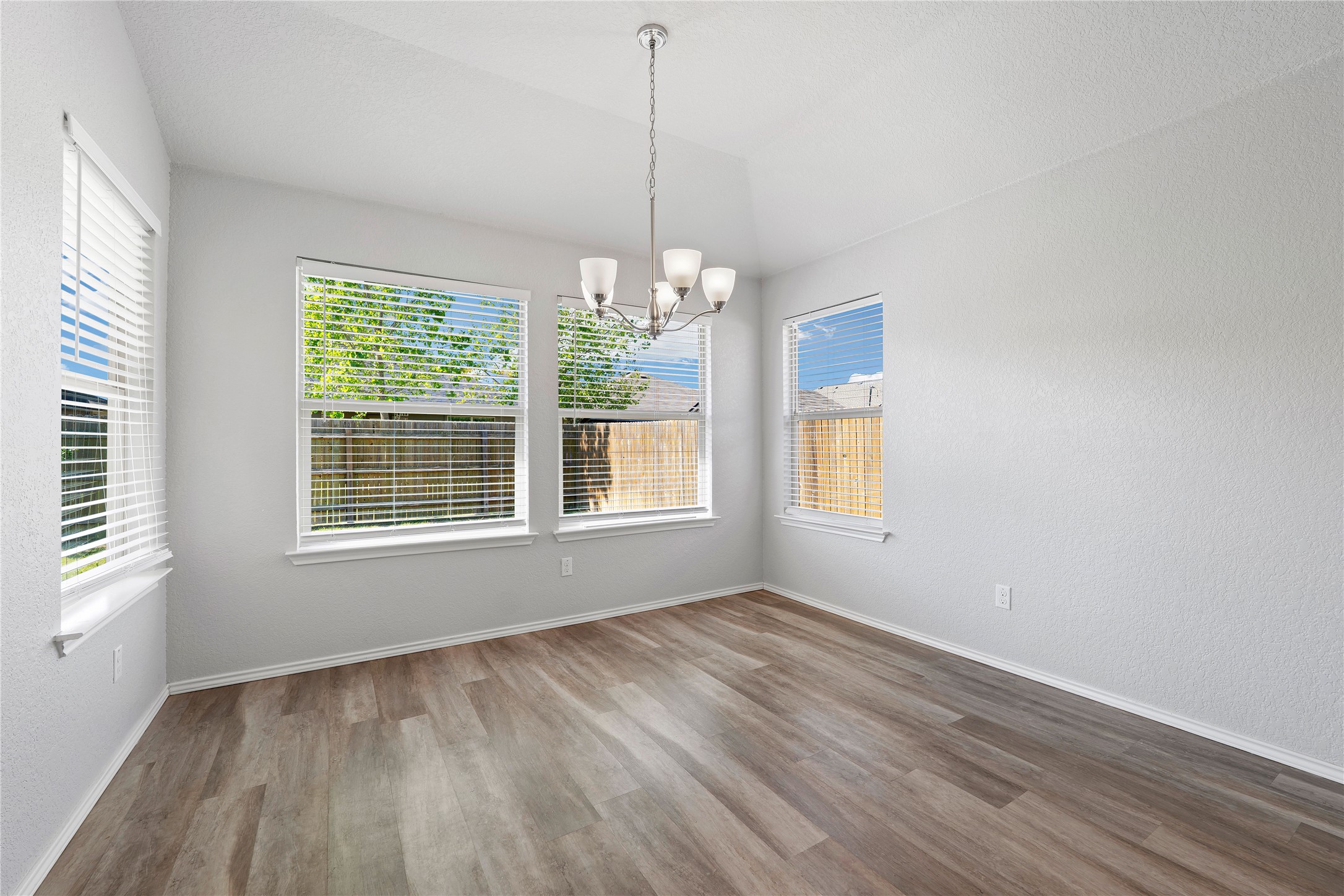 133 Beth Ann Loop Taylor, TX 76574 - Photo 29 of 30 Dining area with suspended lighting, a textured wall, and vaulted ceiling