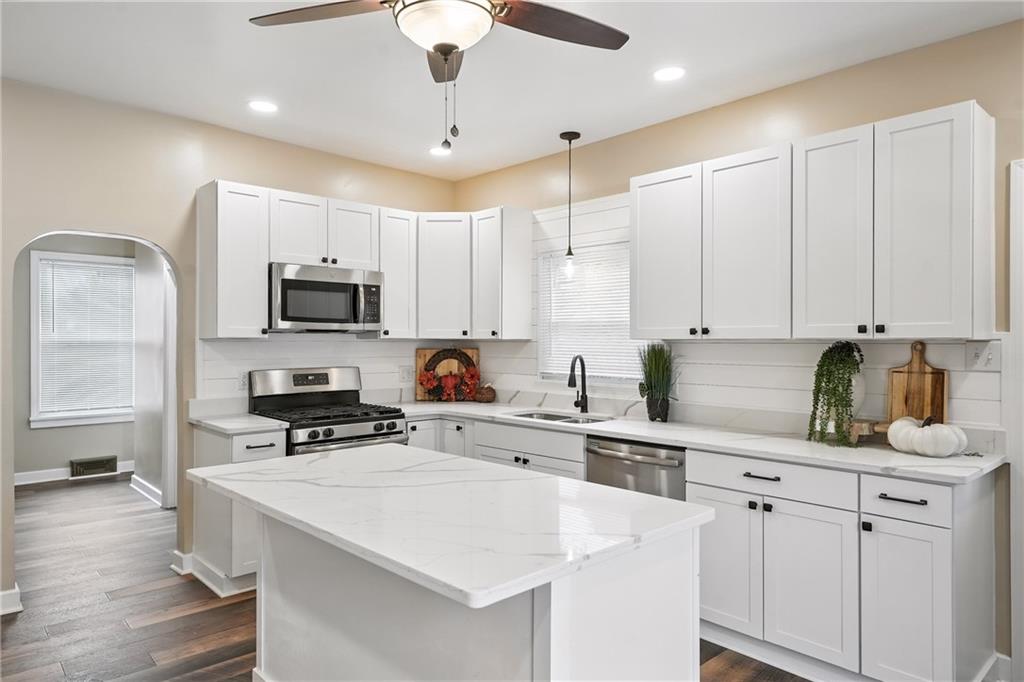 1430 Old Butler Road New Castle, PA 16101 - Photo 6 of 31 a kitchen with stainless steel appliances white cabinets a sink a stove a refrigerator and island with wooden floor