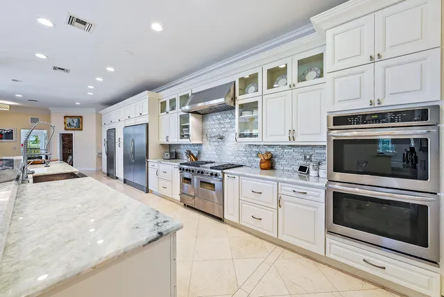 a large kitchen with stainless steel appliances granite countertop a stove a sink and a microwave