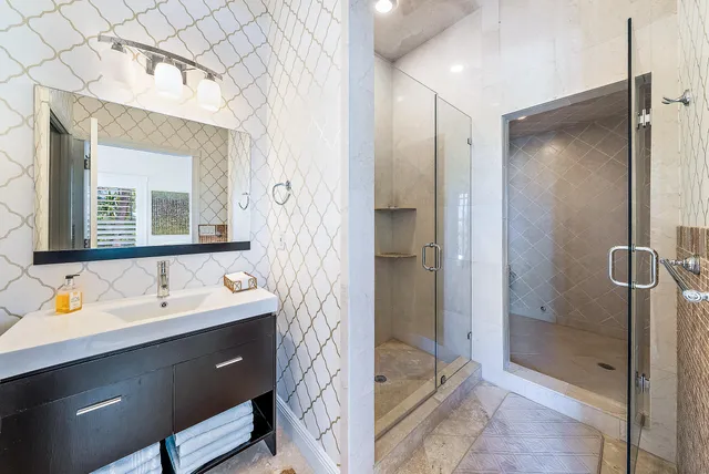 a bathroom with a double vanity sink mirror and shower