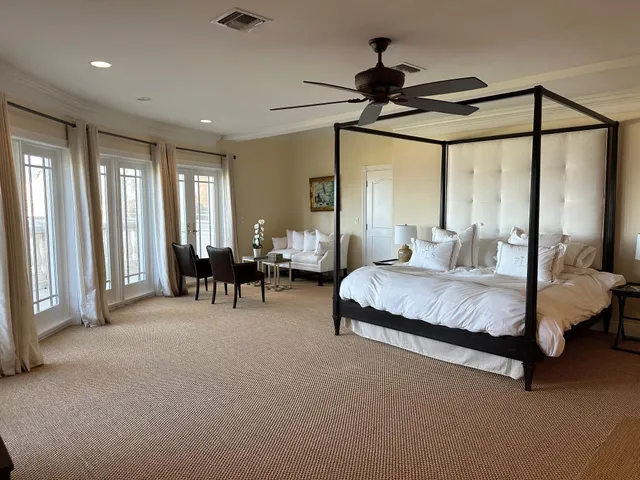 a spacious bedroom with a bed a chandelier and a window