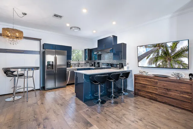a living room with stainless steel appliances furniture and a flat screen tv