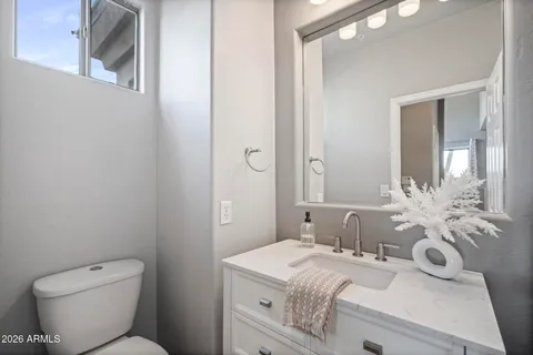 a bathroom with a granite countertop sink a toilet and a mirror