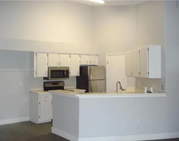 a kitchen with appliances a sink and cabinets