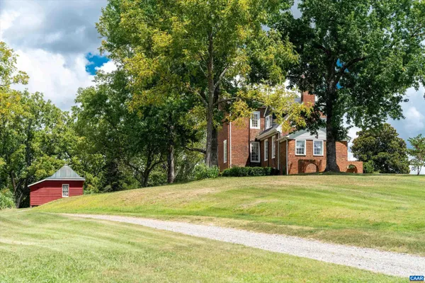 an aerial view of residential houses with outdoor space and trees
