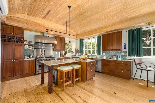 a kitchen with stainless steel appliances granite countertop a stove a sink and a wooden cabinets
