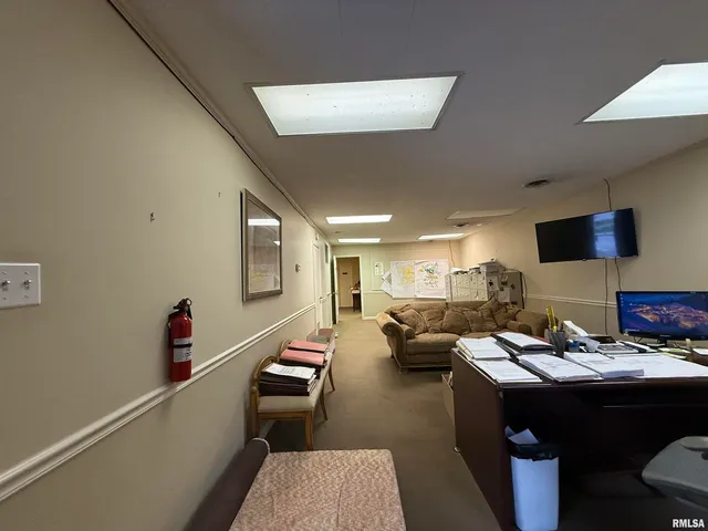 a living room with furniture kitchen view and a wooden floor