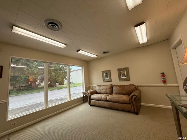 a living room with furniture and a floor to ceiling window