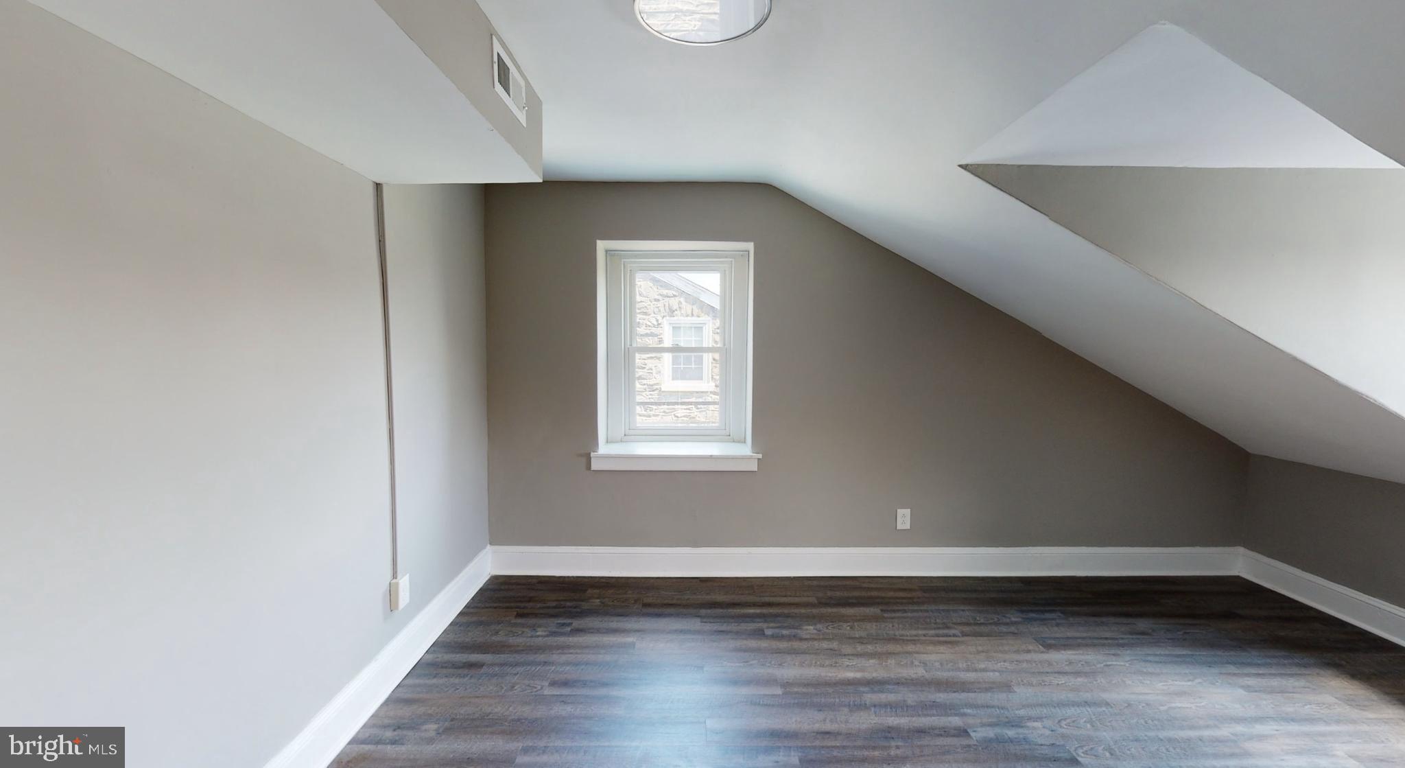 38 Copley Road Upper Darby, PA 19082 - Photo 6 of 22 a view of an empty room with wooden floor and a window