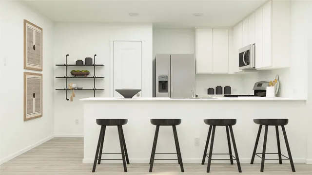 a kitchen with stainless steel appliances granite countertop white cabinets and chair