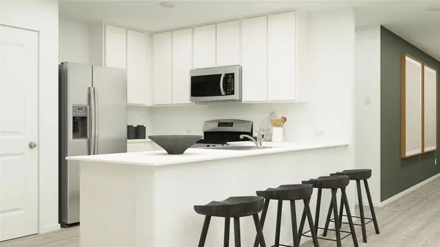 a kitchen with stainless steel appliances a microwave a sink and white cabinets