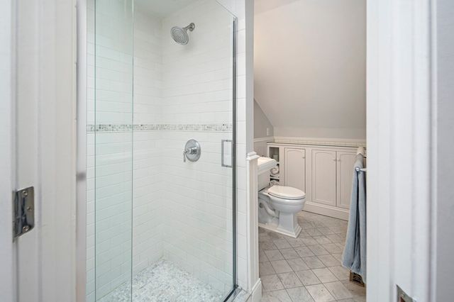 a bathroom with a granite countertop toilet and a shower