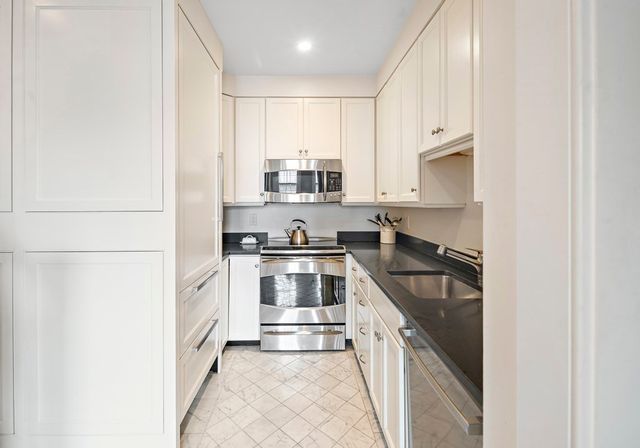 a kitchen with stainless steel appliances granite countertop a stove a sink and a refrigerator
