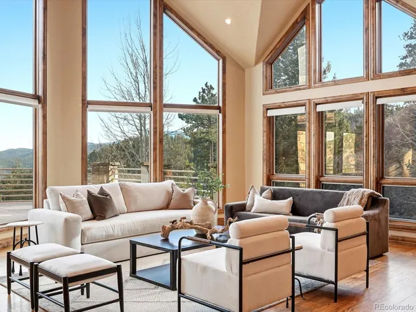 a living room with furniture fireplace and large windows