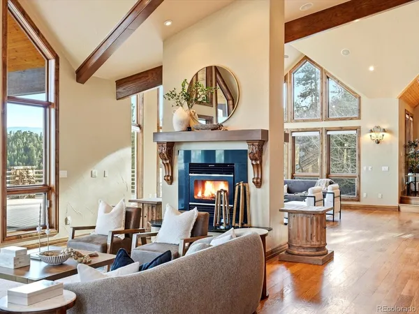 a living room with furniture a fireplace and a large window