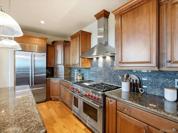 a kitchen with kitchen island granite countertop a stove and a view of living room