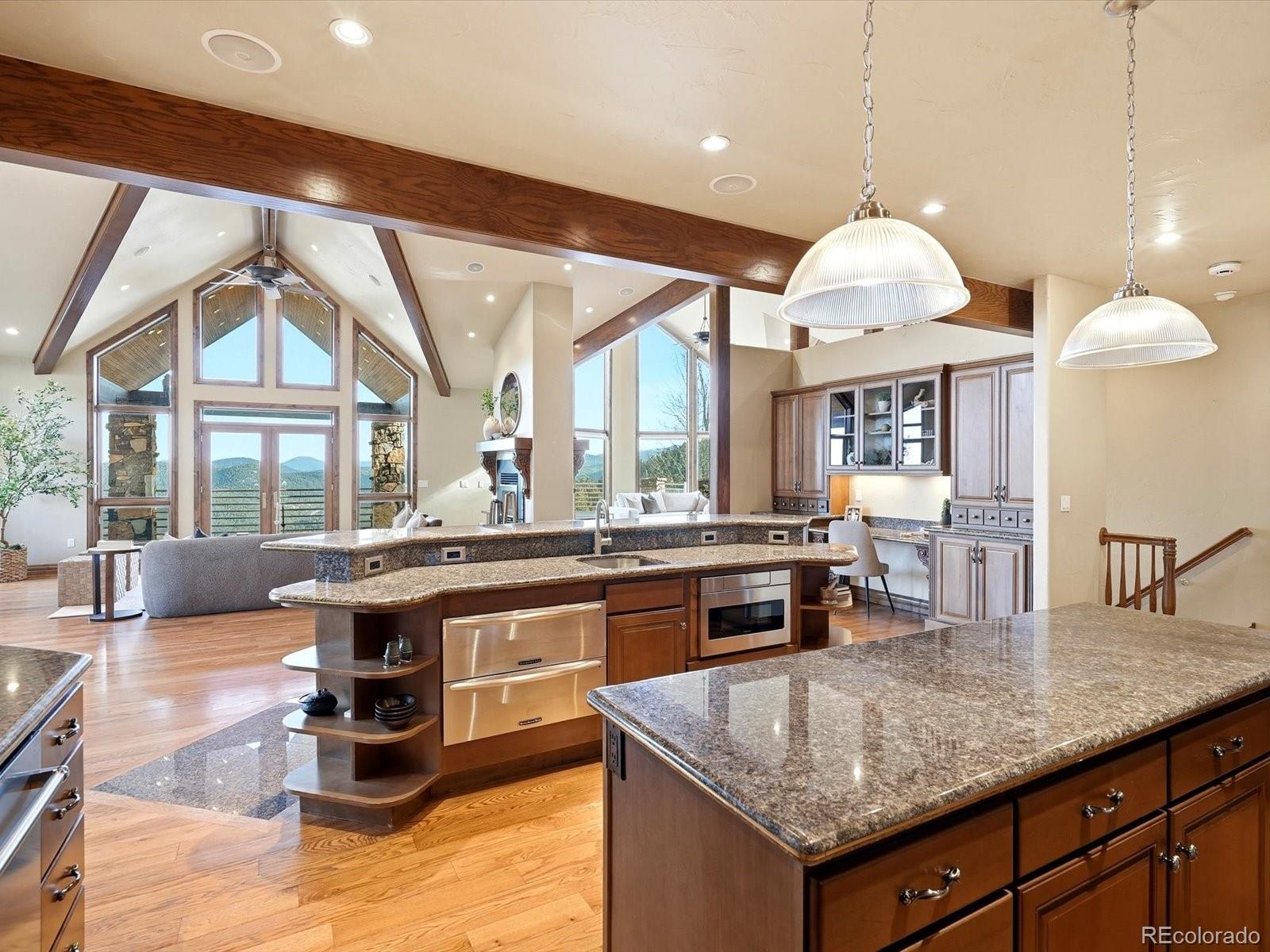 187 Fox Ridge Drive Evergreen, CO 80439 - Photo 23 of 49 a kitchen with kitchen island granite countertop a stove and a view of living room