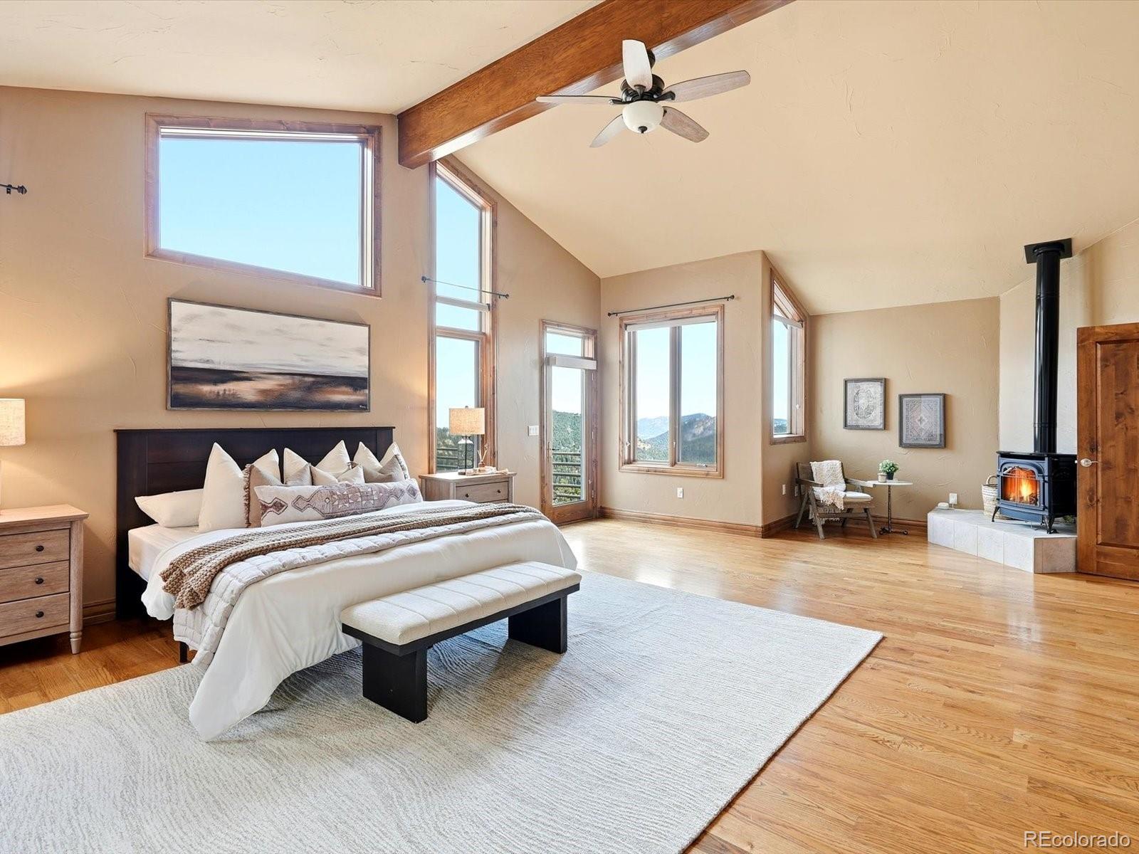 187 Fox Ridge Drive Evergreen, CO 80439 - Photo 29 of 49 a spacious bedroom with a bed a couch and large windows