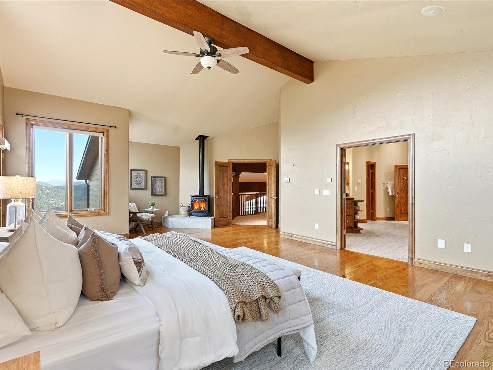 187 Fox Ridge Drive Evergreen, CO 80439 - Photo 32 of 49 a bedroom with a large bed and a chandelier