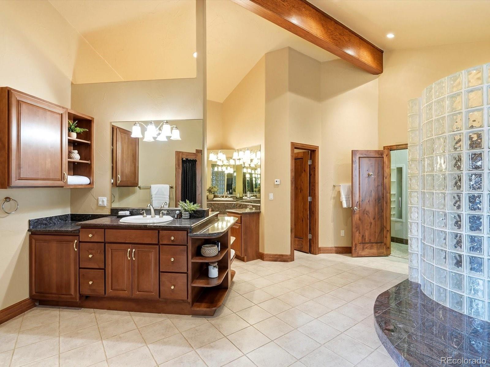 187 Fox Ridge Drive Evergreen, CO 80439 - Photo 33 of 49 a spacious bathroom with a granite countertop sink a toilet and a mirror