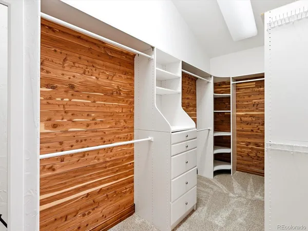 a view of walk in closet with clothes and shoes