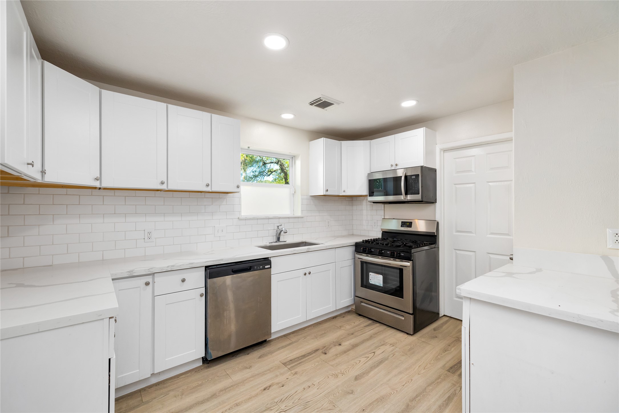 24118 Spring Mill Lane Spring, TX 77373 - Photo 11 of 24 a kitchen with cabinets stainless steel appliances a sink and wooden floor