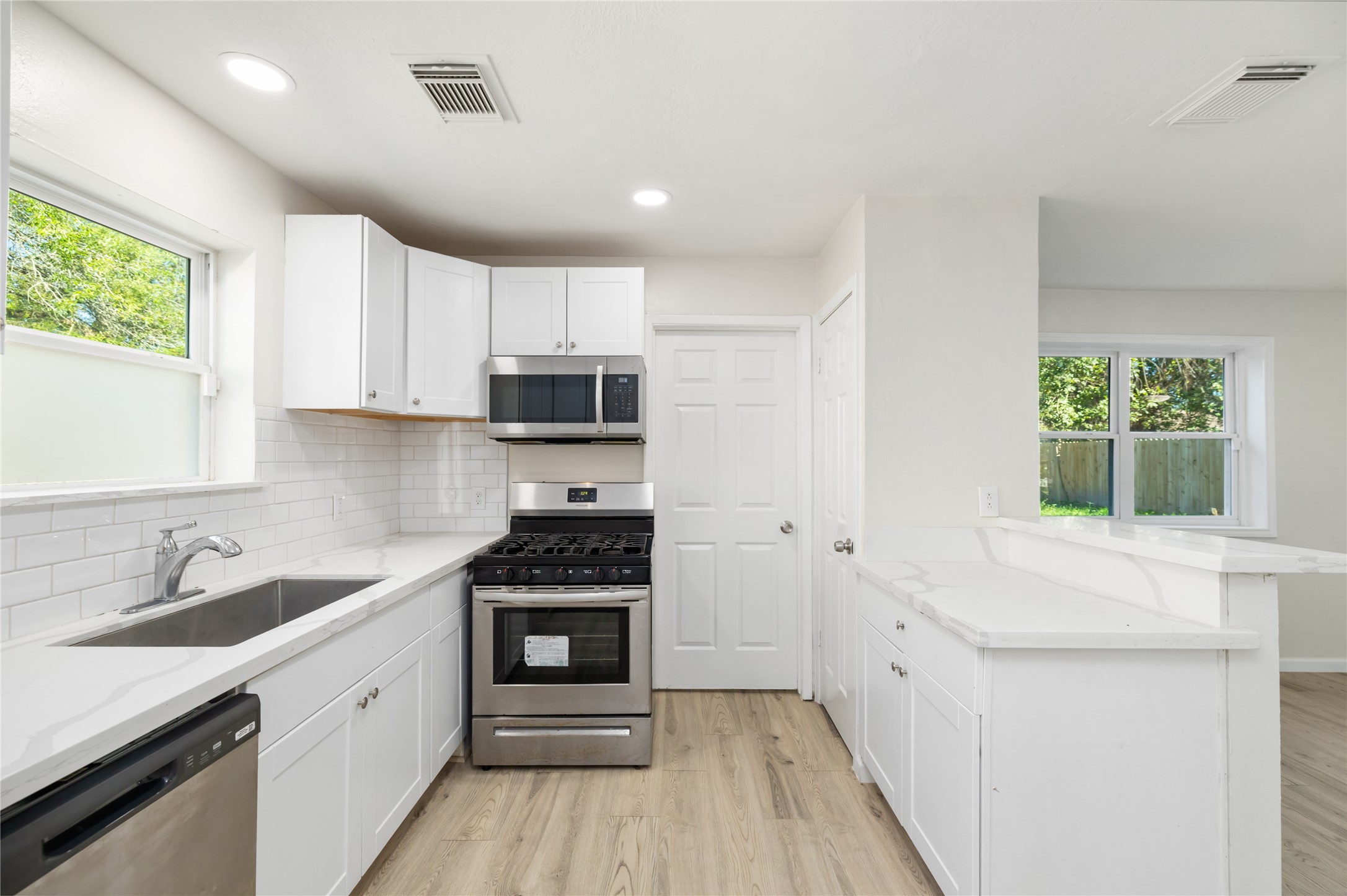 24118 Spring Mill Lane Spring, TX 77373 - Photo 12 of 24 a kitchen with stainless steel appliances a stove sink microwave and cabinets