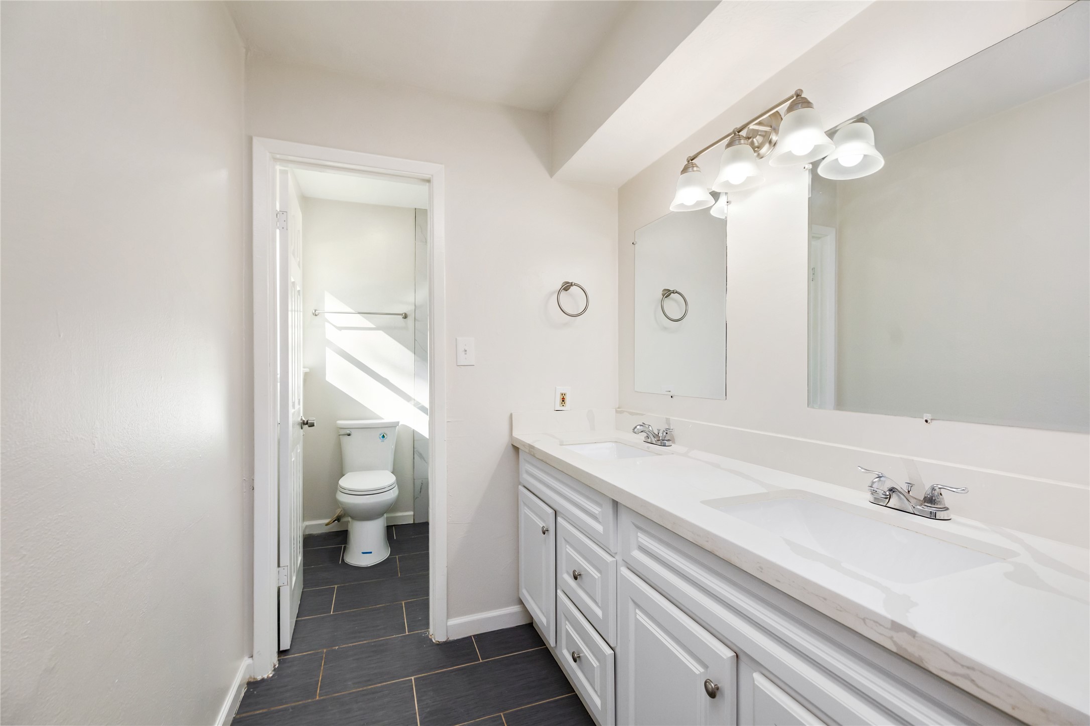 24118 Spring Mill Lane Spring, TX 77373 - Photo 17 of 24 a spacious bathroom with a granite countertop sink a toilet and a mirror