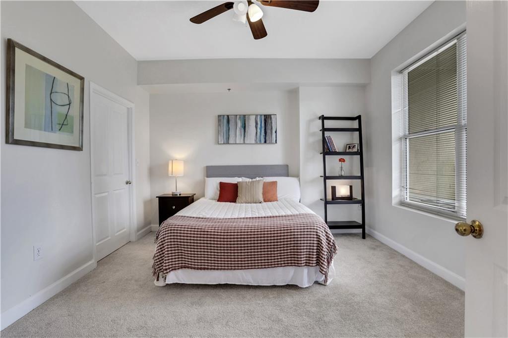 1101 Juniper Street Northeast, Unit 619 Atlanta, GA 30309 - Photo 13 of 28 a bedroom with a bed a couch and a window