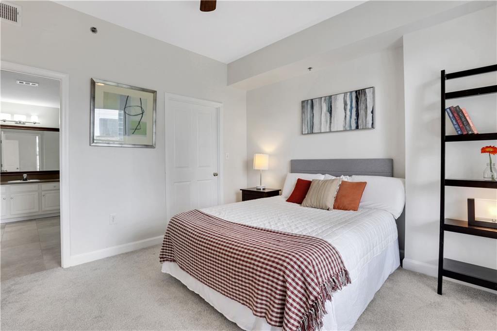 1101 Juniper Street Northeast, Unit 619 Atlanta, GA 30309 - Photo 14 of 28 a bedroom with a bed and a painting on the wall