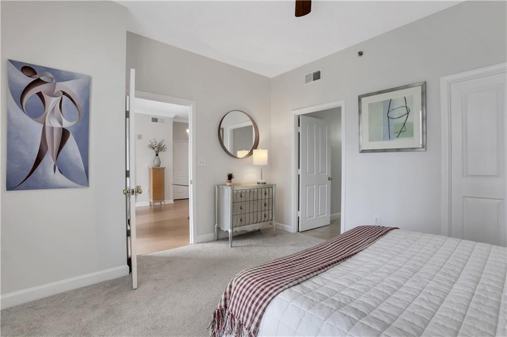 1101 Juniper Street Northeast, Unit 619 Atlanta, GA 30309 - Photo 15 of 28 a bedroom with a bed and a chandelier