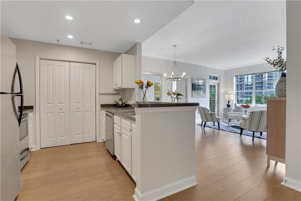 1101 Juniper Street Northeast, Unit 619 Atlanta, GA 30309 - Photo 2 of 28 a kitchen with stainless steel appliances kitchen island granite countertop a refrigerator a stove a dining table and chairs with wooden floor