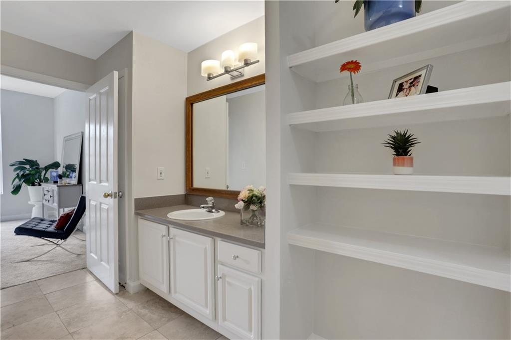 1101 Juniper Street Northeast, Unit 619 Atlanta, GA 30309 - Photo 23 of 28 a bathroom with a granite countertop sink and a mirror