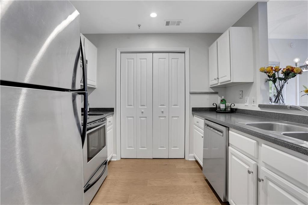 1101 Juniper Street Northeast, Unit 619 Atlanta, GA 30309 - Photo 3 of 28 a kitchen with white cabinets and white appliances