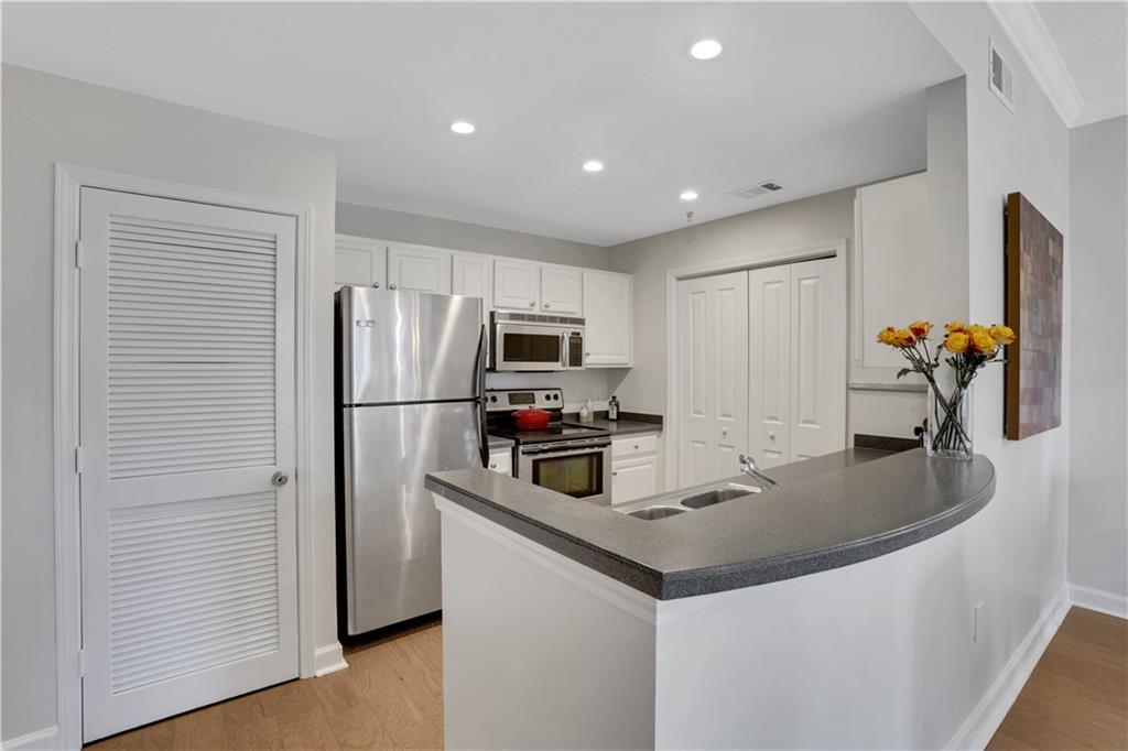 1101 Juniper Street Northeast, Unit 619 Atlanta, GA 30309 - Photo 6 of 28 a kitchen with stainless steel appliances granite countertop a sink a refrigerator and a refrigerator