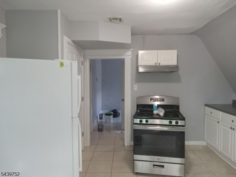 58 North 5th Street, Unit 3 Newark, NJ 07107 - Photo 11 of 11 a kitchen with stainless steel appliances a stove and white cabinets