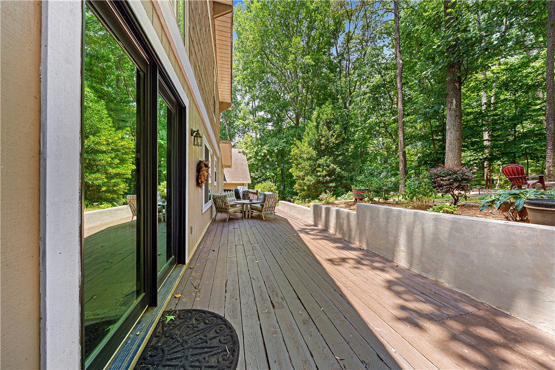 139 Tulip Lane Westminster, SC 29693 - Photo 14 of 37 A spacious wooden deck provides an inviting outdoor entertaining area, framed by lush trees and landscaping.
