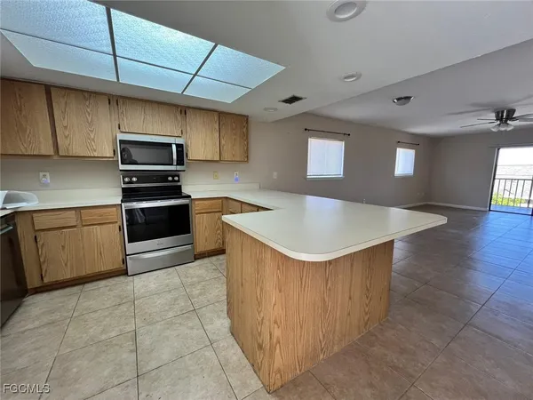 a kitchen with stainless steel appliances granite countertop a sink a stove top oven a counter space and cabinets