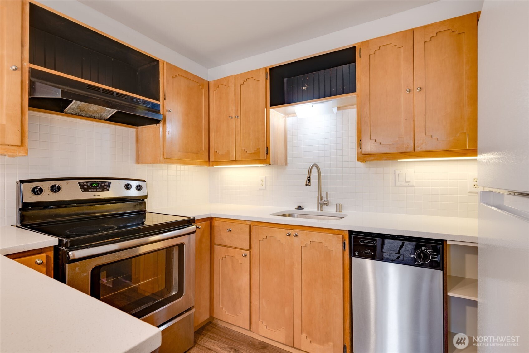 1425 South Puget Drive, Unit B3 Renton, WA 98055 - Photo 10 of 24 a kitchen with stainless steel appliances a stove a microwave and a sink