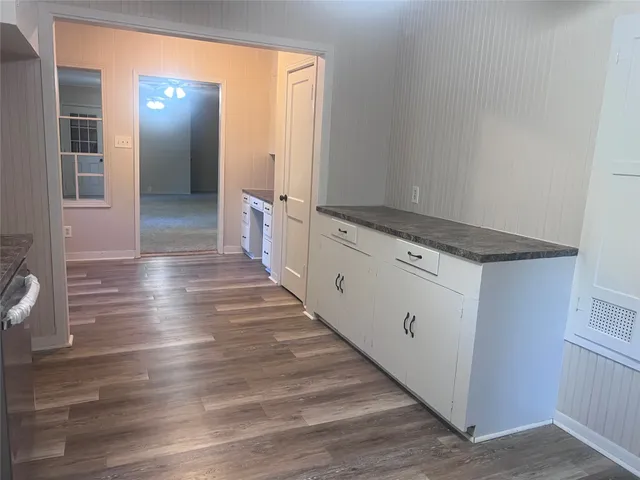 a kitchen with stainless steel appliances granite countertop a stove a sink and white cabinets