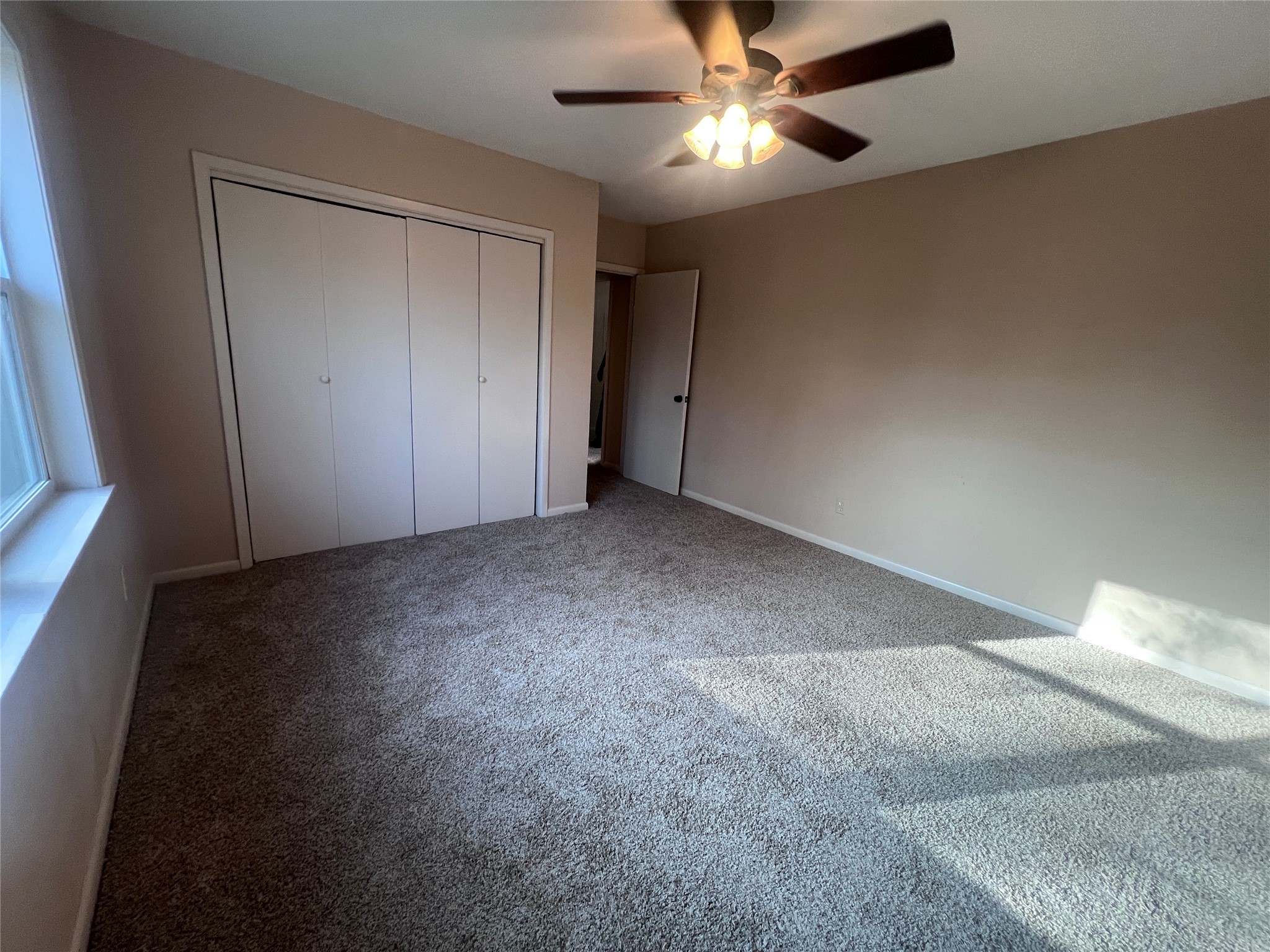 620 Koehl Street Wharton, TX 77488 - Photo 22 of 37 an empty room with a ceiling fan and a window