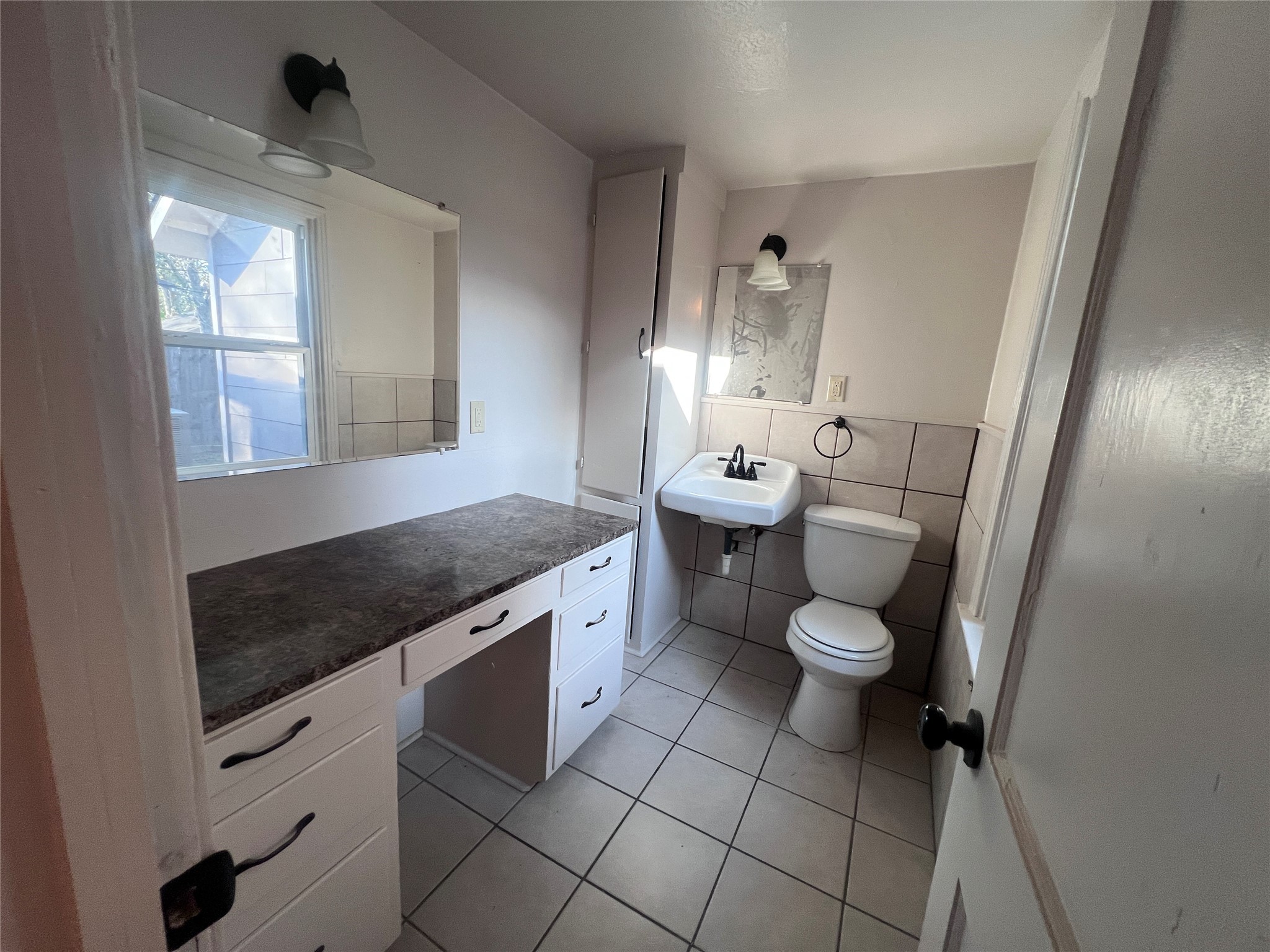 620 Koehl Street Wharton, TX 77488 - Photo 29 of 37 a spacious bathroom with a granite countertop sink a toilet a mirror and window