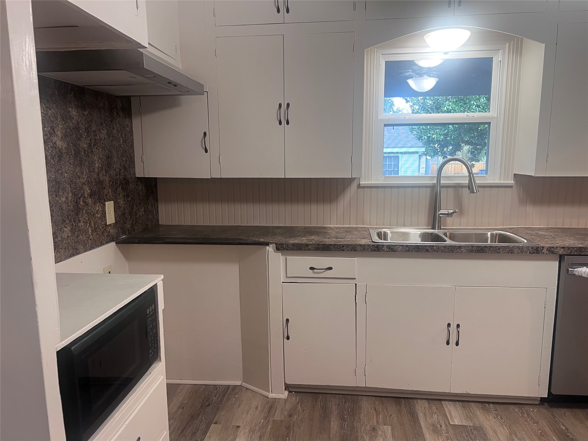 620 Koehl Street Wharton, TX 77488 - Photo 10 of 37 a kitchen with granite countertop white cabinets and window