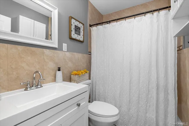 a bathroom with a sink a toilet and a mirror